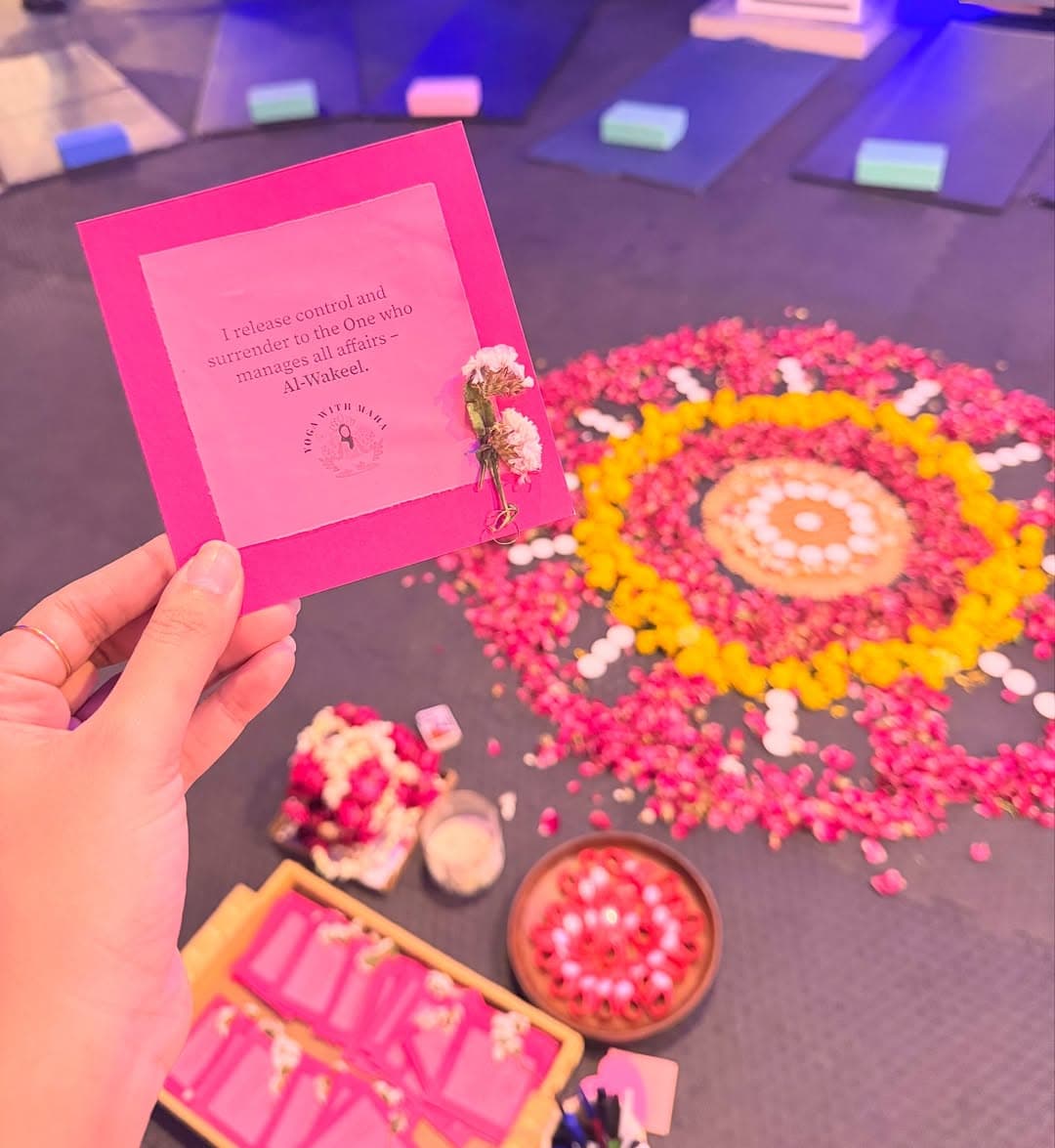 Hand holding a mindful quote card over a flower mandala